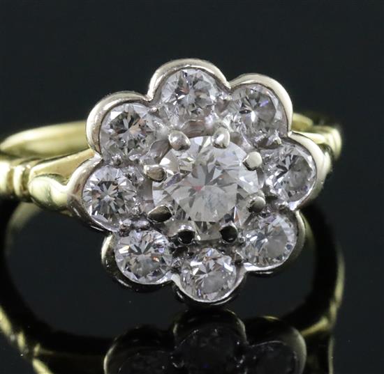A modern 18ct gold and nine stone diamond flowerhead cluster ring, size J.